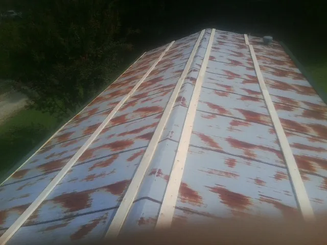 Rusted metal roof panels with new wood purlins before replacement — Storm Damage Roof Repair in Ogden by Roofing Brothers