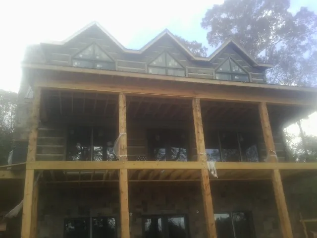 Dormers and porch framing on a large log home under construction — Roof Coating work by our crew in Ogden